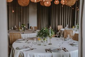 ein Esszimmer mit Tischen, weißen Tischdecken und Stühlen in der Unterkunft Hotel Saltic Resort & Spa Łeba in Łeba + 37 Fotos
