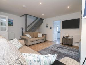 a living room with a couch and a tv at Beach Cottage in Redruth