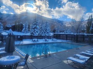 a swimming pool covered in snow with tables and chairs at Beautiful home with 1bedroom and huge open loft. in Park City