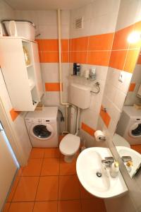 ein orangefarbenes und weißes Badezimmer mit einem WC und einem Waschbecken in der Unterkunft Thomas apartment 028 in Ljubljana