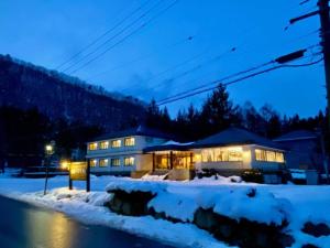 uma casa na neve à noite em Hakuba park hotel - Vacation STAY 95996v em Hakuba