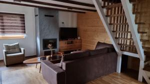 a living room with a couch and a table at Brvnare Golo Brdo in Mokra Gora