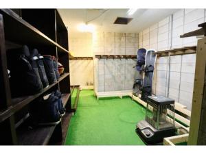 a room with a green floor in a room with shoes at Hakuba park hotel - Vacation STAY 95996v in Hakuba