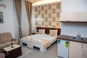 a small bedroom with a bed and a sink at Hotel North City in Mitrovica