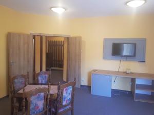 a room with a table and a tv on the wall at Vila Predeal Holidays in Predeal