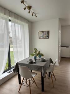 a dining room with a table and two chairs at Marupe Saules in Mārupe