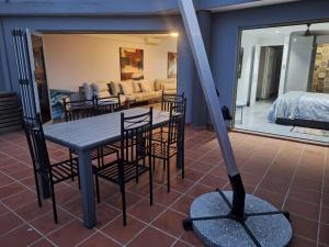 a table and chairs in a room with a bedroom at SEA FACING modern 3-bedroom apartment, Umdloti in Umdloti