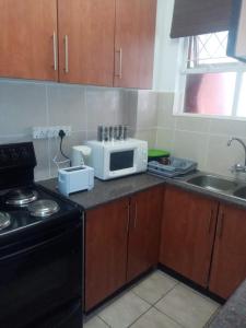 a kitchen with a microwave and a stove top oven at Happy days in Amanzimtoti