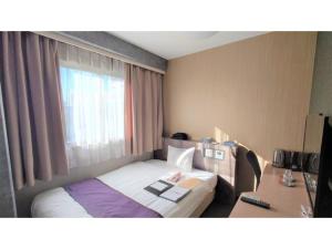 um quarto de hotel com uma cama e uma janela em Hotel Area One Oita - Vacation STAY 99735v em Oita
