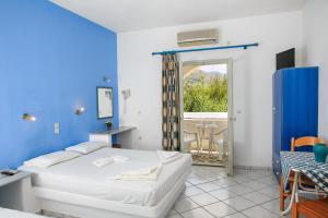 1 dormitorio con cama blanca y pared azul en Ampeli Apartments, en Parikia