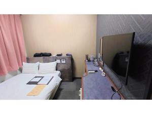 a small room with a bed and a television at Hotel Area One Oita - Vacation STAY 99740v in Oita