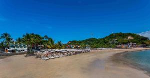 a beach with chairs and umbrellas and the ocean at Aqua by Sambass in Morro de São Paulo