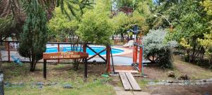 um parque com um parque infantil com uma piscina e uma placa em Cabaña Paso De Los Toros, San Fabian de Alico em San Fabián de Alico
