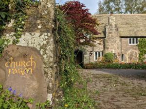 a stone house with a sign in front of it at Converted stables and hayloft in former farmyard in Saint Briavels