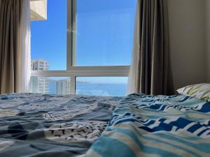 a bedroom with a bed with a large window at Departamento Sector Casino Enjoy in Coquimbo