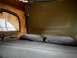 a bed with two pillows in a tent at Embark on a journey through Maui with Aloha Glamp's jeep and rooftop tent allows you to discover diverse campgrounds, unveiling the island's beauty from unique perspectives each day in Paia