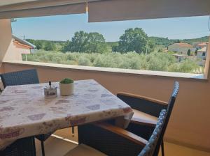 d'une table, de chaises et d'une fenêtre. dans l'établissement Apartmani Bernarda, à Poreč