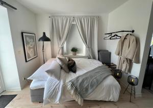 a bedroom with a bed with white sheets and a window at Fully Equipped Cosy Flat Close to Malmö&Copenhagen in Vellinge