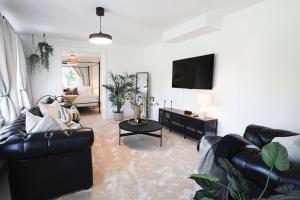 a living room with two couches and a flat screen tv at Fully Equipped Cosy Flat Close to Malmö&Copenhagen in Vellinge