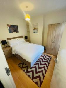 a bedroom with a bed and a rug on the floor at Baravaggio By Kasar Stays in Leicester