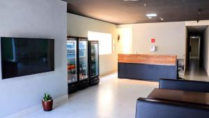 una sala d'attesa di un ospedale con una grande TV di Hotel Fly - Aeroporto Cuiabá a Várzea Grande