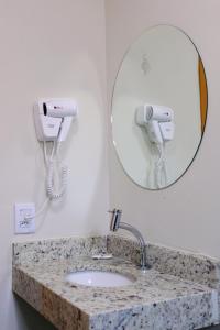 uma casa de banho com um lavatório e um espelho em Hotel Fly - Aeroporto Cuiabá em Várzea Grande