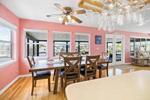 a dining room with pink walls and a table and chairs at Waterfront home with pool and gameroom! in Hernando Beach