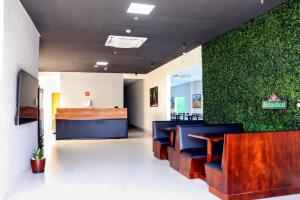 a lobby of a restaurant with a green wall at Hotel Fly - Aeroporto Cuiabá in Várzea Grande