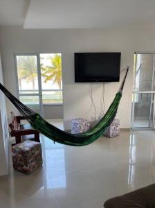 un hamac dans un salon avec une télévision dans l'établissement Casa Condomínio FRENTE PARA O MAR, à Praia Grande 41 autres photos