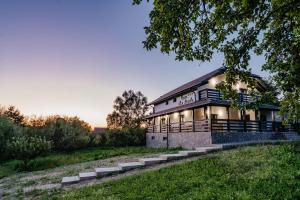 a house with lights on the side of it at Casa din livada in Dragomireşti