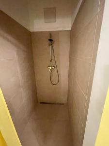 a shower with a hose in a bathroom at Der Salon Hostel in Vienna