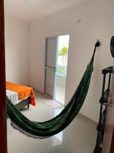 un hamac vert dans une chambre dans l'établissement Casa Condomínio FRENTE PARA O MAR, à Praia Grande