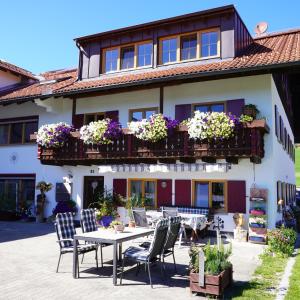 ein Haus mit einem Tisch und Stühlen davor in der Unterkunft Ferienwohnung Linder in Hopferau