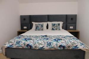 a bedroom with a large bed with a gray headboard at Casa din livada in Dragomireşti
