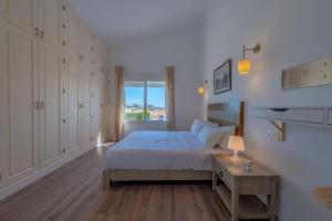 ein weißes Schlafzimmer mit einem Bett und einem Fenster in der Unterkunft unique flat_ garden and lagoon in Hurghada