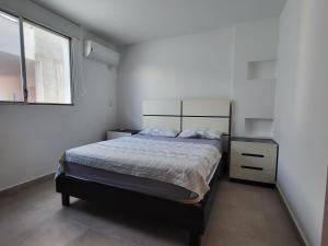 Un dormitorio con una cama grande y una ventana en Suite Dptm BRISAMAR Playa Santa Marianita Manta, en Manta