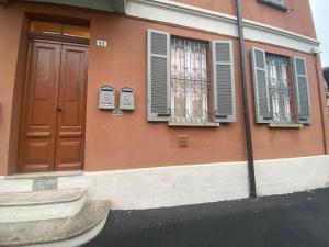 um edifício cor-de-rosa com janelas, uma porta e uma rua em MILANO 11 em Arona