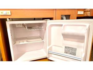 an empty refrigerator with its door open in a kitchen at Hotel Sunroute Patio Goshogawara - Vacation STAY 30370v in Goshogawara