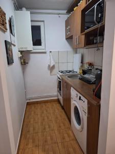 uma pequena cozinha com uma máquina de lavar roupa e uma máquina de lavar roupa em A&M em Târgu-Mureş