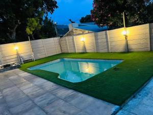 a swimming pool in a yard with green grass at African Haven Guest House in Cape Town +14 photos