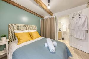 - une chambre avec un lit doté d'oreillers jaunes et blancs dans l'établissement Le Refuge, T2 élégant Aéroport d'Orly, à Athis-Mons