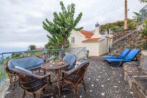 a patio with a table and chairs on a balcony at Casa da Vizinha in Ponta do Sol