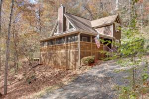 a home with a wrap around porch in the woods at Enchanted Forest Cottage with Hot Tub! in Hiawassee