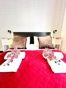 een rood bed met witte handdoeken en bloemen erop bij Giuliano Guest House in Rome