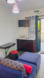 Sala de estar con 2 camas y mesa en AHAVAH, en Trou d'Eau Douce