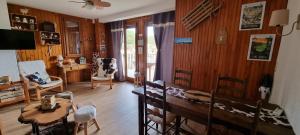 a living room with wooden walls and a table and chairs at APPART 2 chambres DECO CHALET & VUE IMPRENABLE MONTAGNE in Font-Romeu-Odeillo-Via