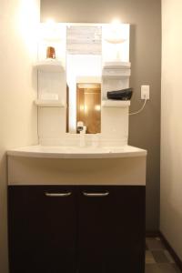 La salle de bains est pourvue d'un lavabo et d'un miroir. dans l'établissement Time Traveler Izu-Shuzenji Onsen - Vacation STAY 32421v, à Izu