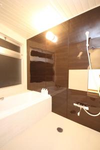 La salle de bains est pourvue d'une baignoire, d'un lavabo et d'un miroir. dans l'établissement Time Traveler Izu-Shuzenji Onsen - Vacation STAY 32421v, à Izu