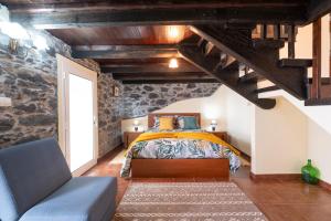 1 dormitorio con 1 cama en una habitación con paredes de piedra en Casa da Vizinha, en Ponta do Sol