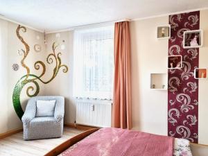 a bedroom with a bed and a chair and a window at Apartment Bayreuth, Große Ferienwohnung im Haus mit Kunst, 3 Schlafzimmer, Küche, Parkplatz in Bayreuth